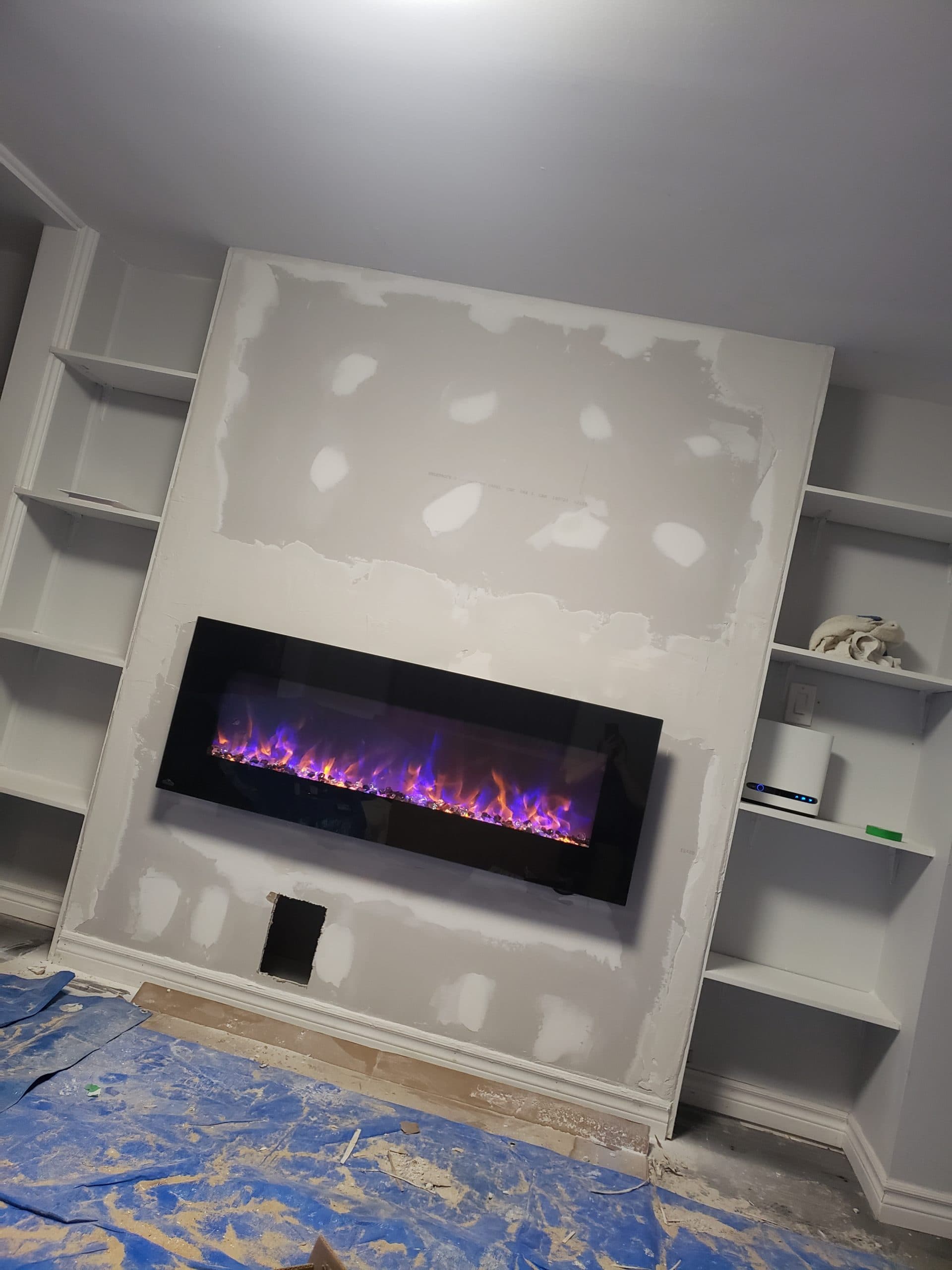 Custom fireplace wall with built-in shelving, mid-drywall
