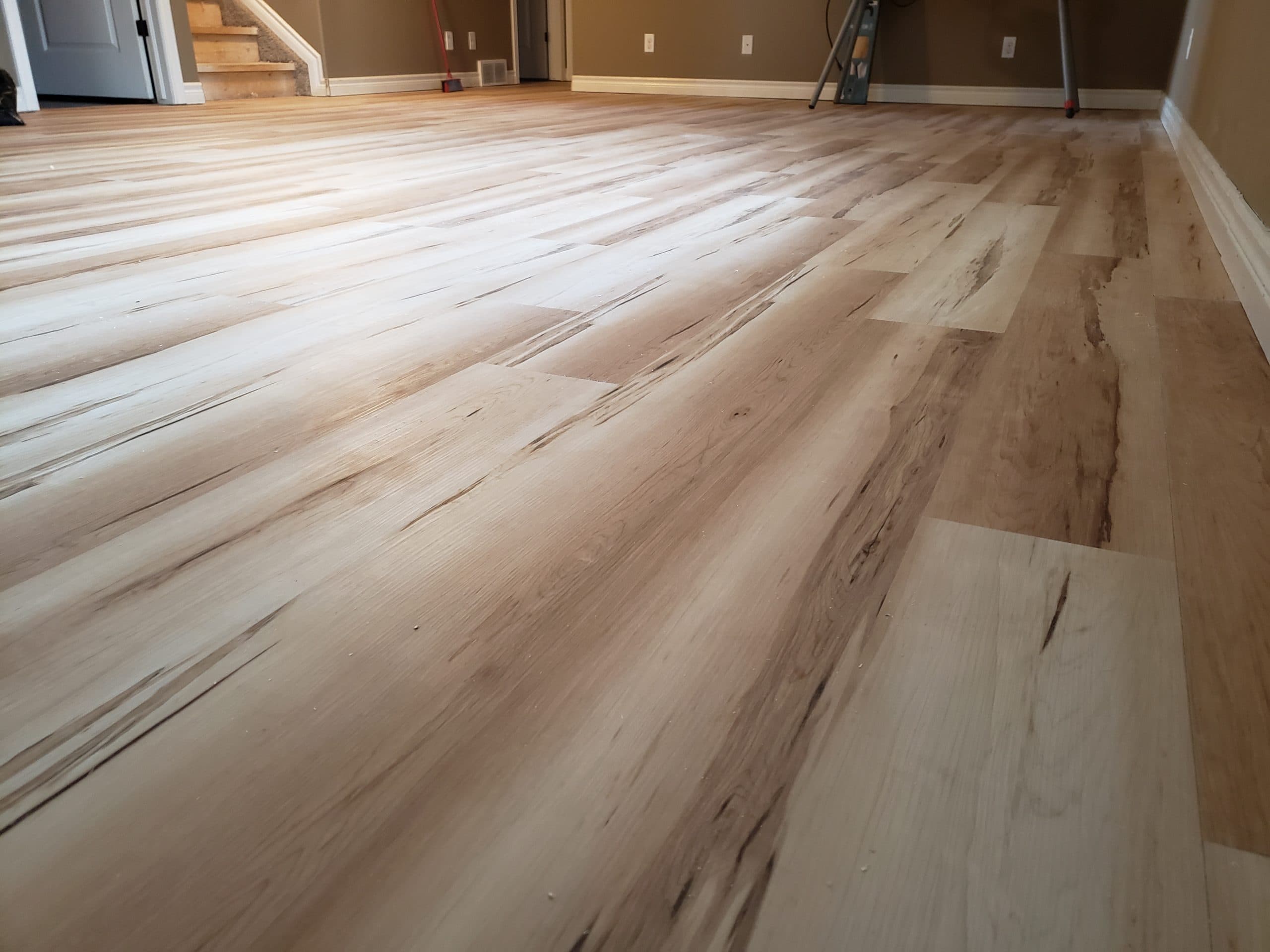 New wide-plank flooring installed across a finished basement