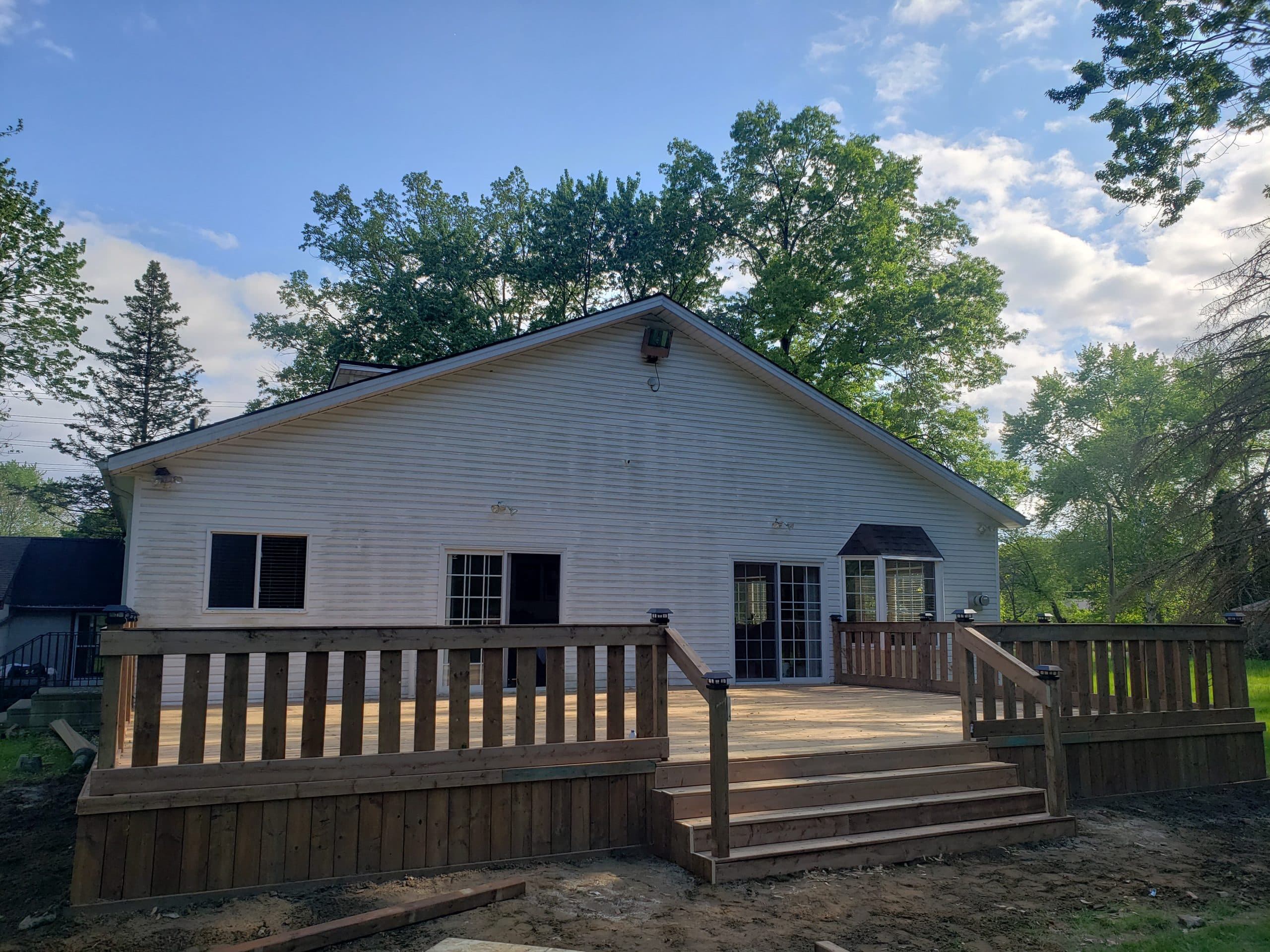 Rebuilt deck with new framing, custom railing, and skirt finish