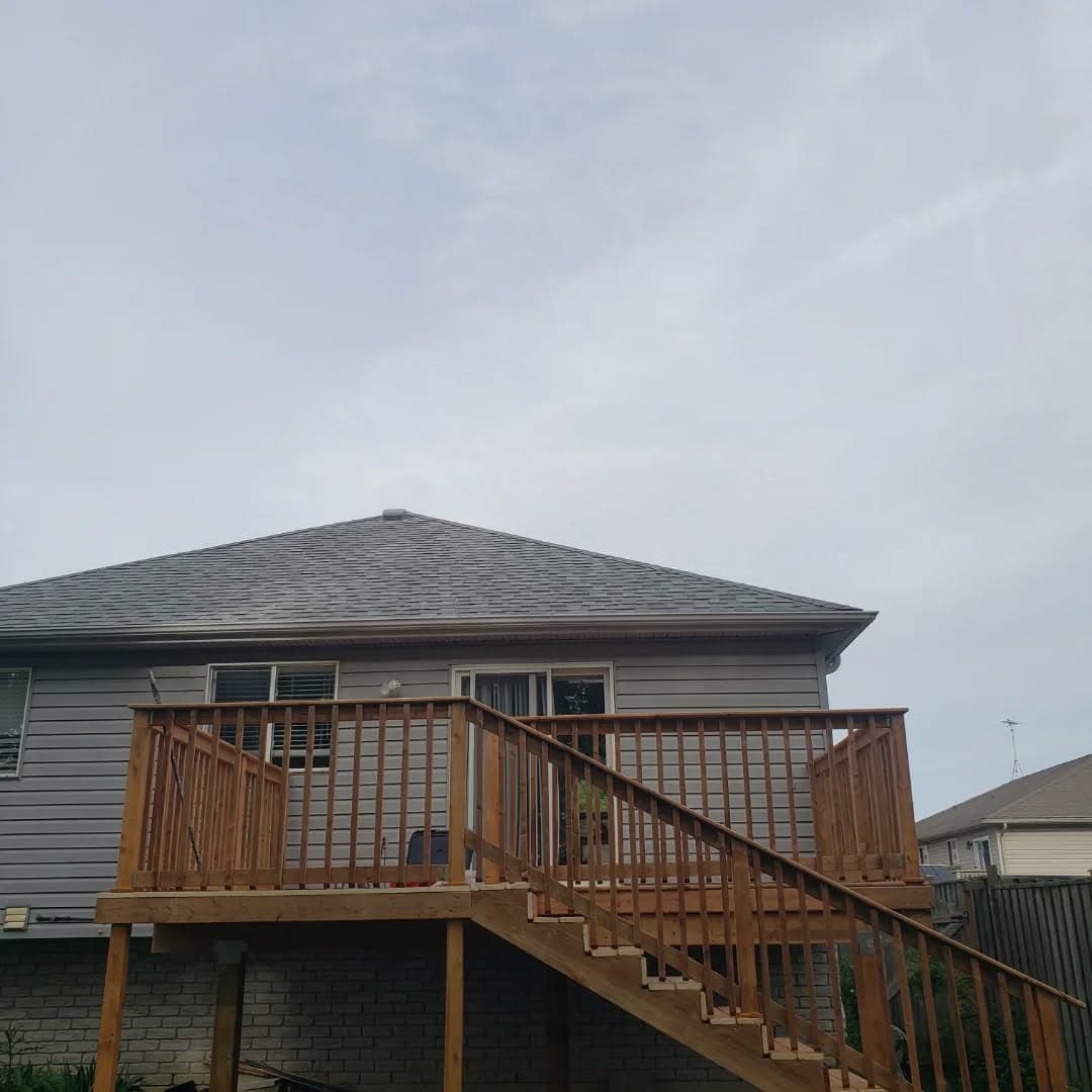 Newly built elevated deck with stairs on the back of a home